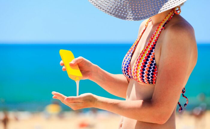 donna al mare con creme solari